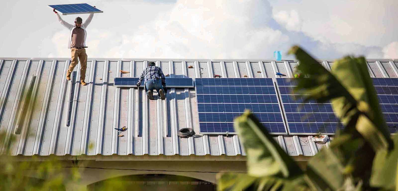 men working on the solar panels at the rooftop men working on the solar panels at the rooftop